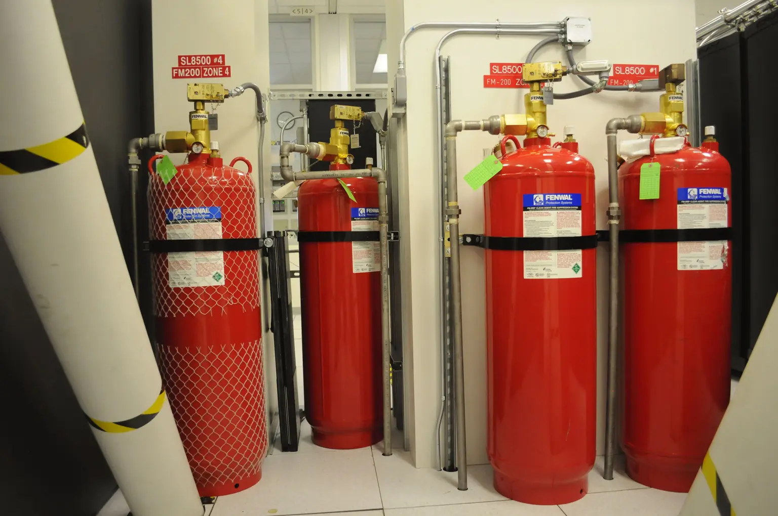Батарея баллонов газового пожаротушения FM-200 в вычислительном центре: запорно-пусковые головки и разводка трубопроводов. Фото: Derrick Coetzee, CC0