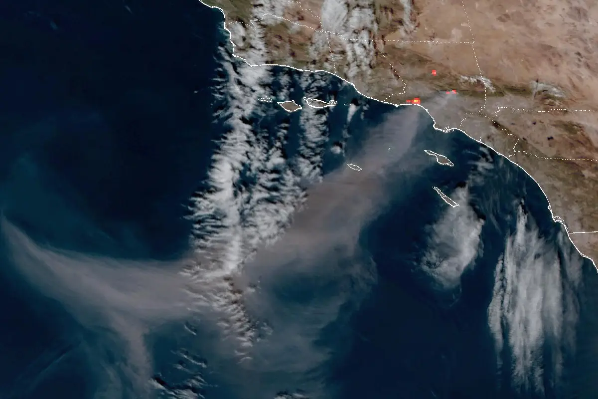 Так видит пожары метеоспутник: снимок GOES-18 от 8 января 2025 года, пожары вокруг Лос-Анджелеса — несколько красных квадратов на побережье, над океаном на сотни километров тянется дым. Фото: NOAA, общественное достояние