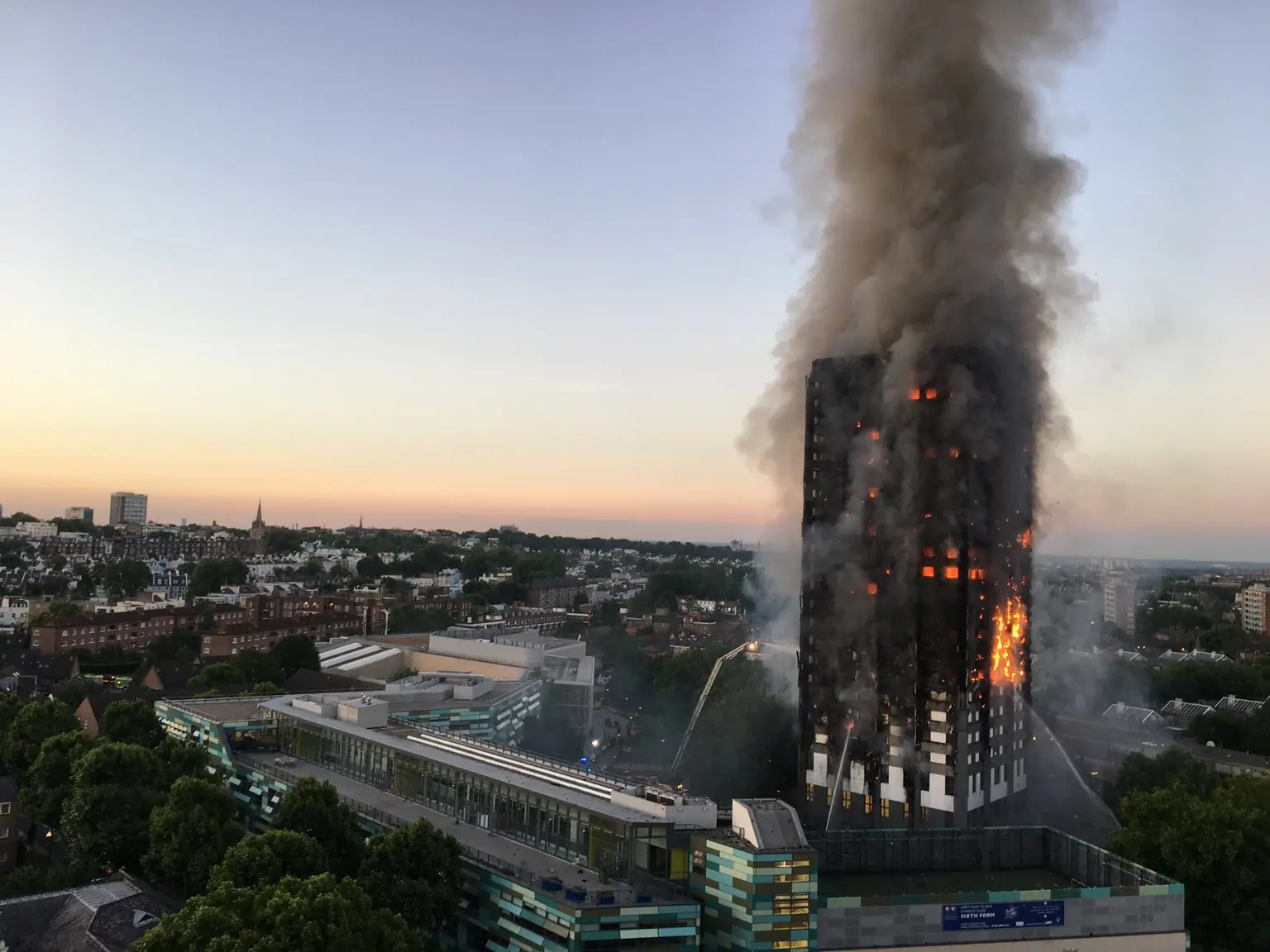 Grenfell Tower в 4:43 утра 14 июня 2017 года: огонь идёт по фасаду на всю высоту башни. Фото: Natalie Oxford, CC BY 4.0