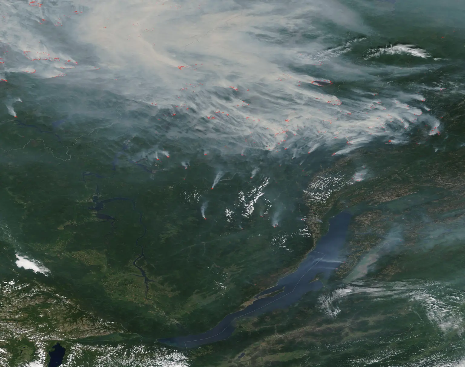 Снимок спектрорадиометра MODIS со спутника Terra, 6 августа 2019 года: тайга к северу от Байкала в дыму, красными метками отмечены сотни очагов — те самые термические точки. Фото: NASA, MODIS Land Rapid Response Team, общественное достояние