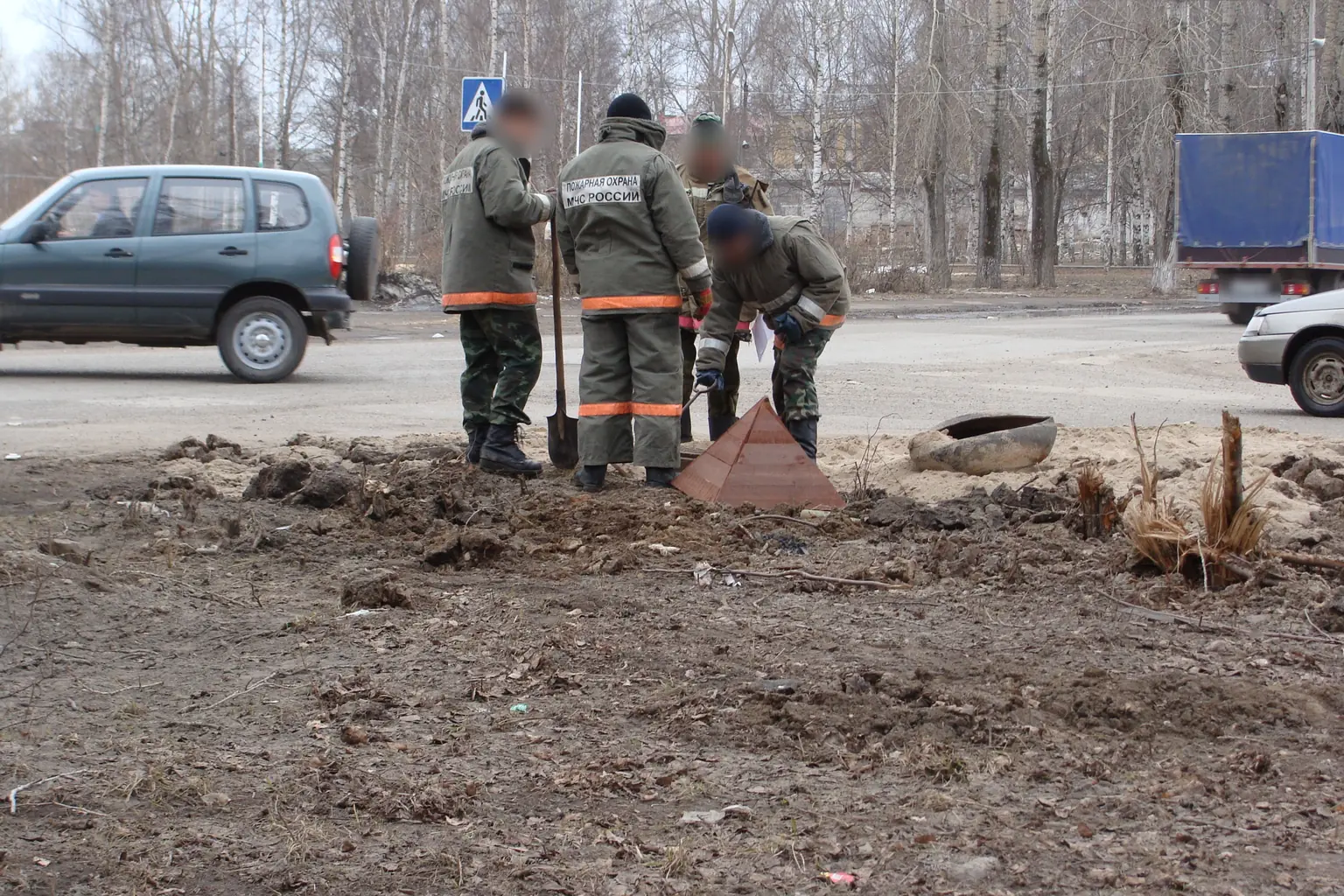 Пожарные части МЧС в Котласе проверяют пожарный гидрант весной 2010 года: открыт люк колодца, рядом поставлен знак. Фото: Georg Pik, общественное достояние